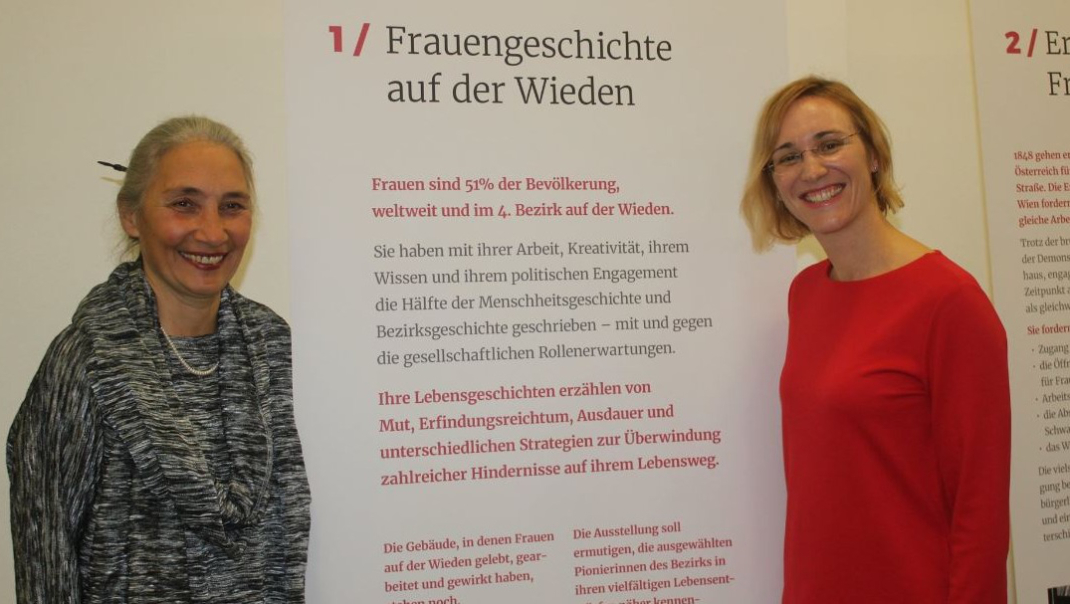 Zwei Frauen vor Plakat zur Frauengeschichte auf der Wieden